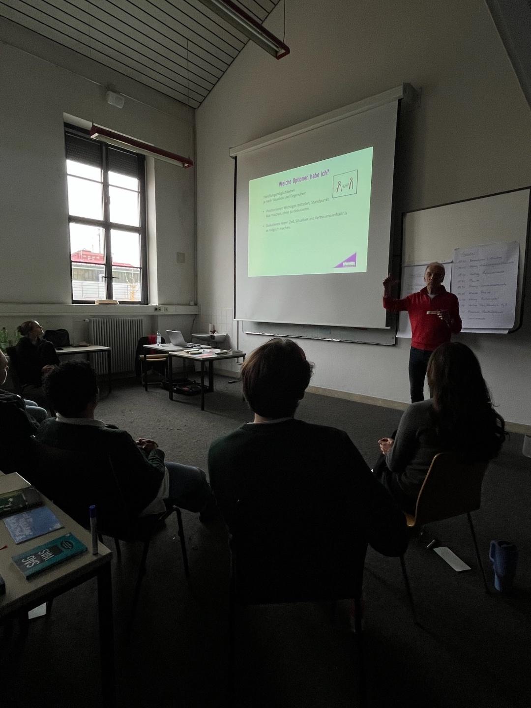 Workshop-Situation mit Präsentation und Teilnehmenden.