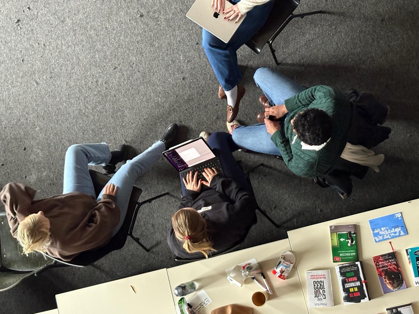 Blick von oben auf eine Gesprächsrunde bei einem Workshop.
