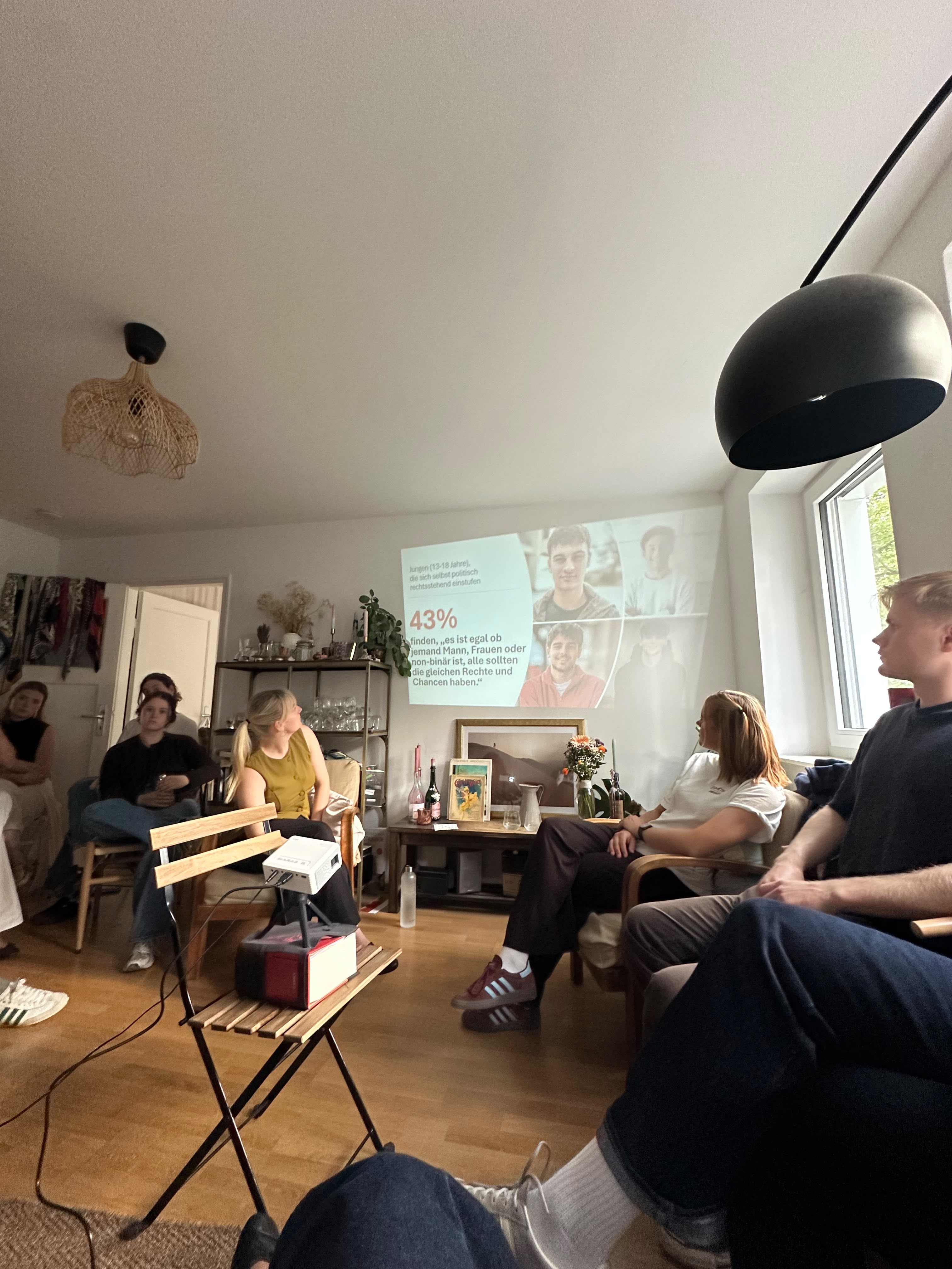 Teilnehmende im Austausch bei der Wohnzimmerdiskussion.
